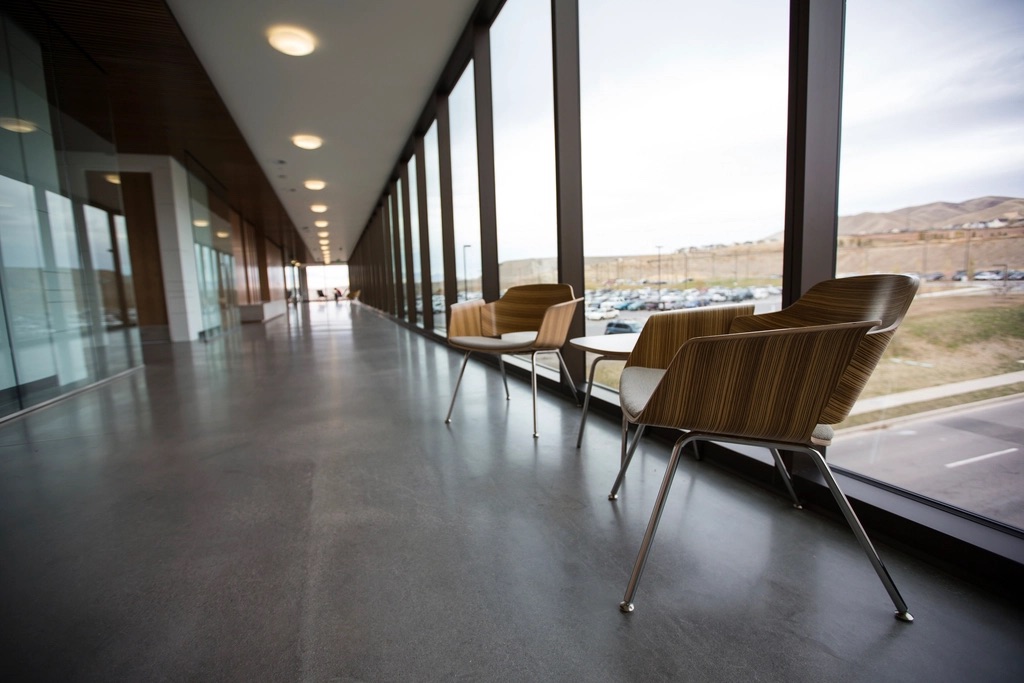 Window-lined corridor with timber lounge chairs